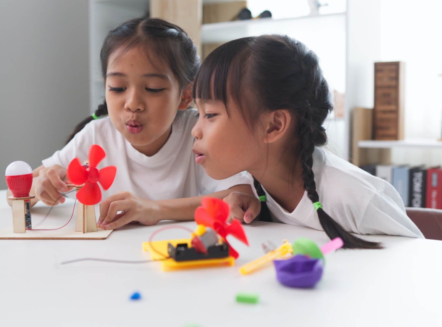 Dwoje dzieci testuje miniwiatraczek w szkolnym eksperymencie