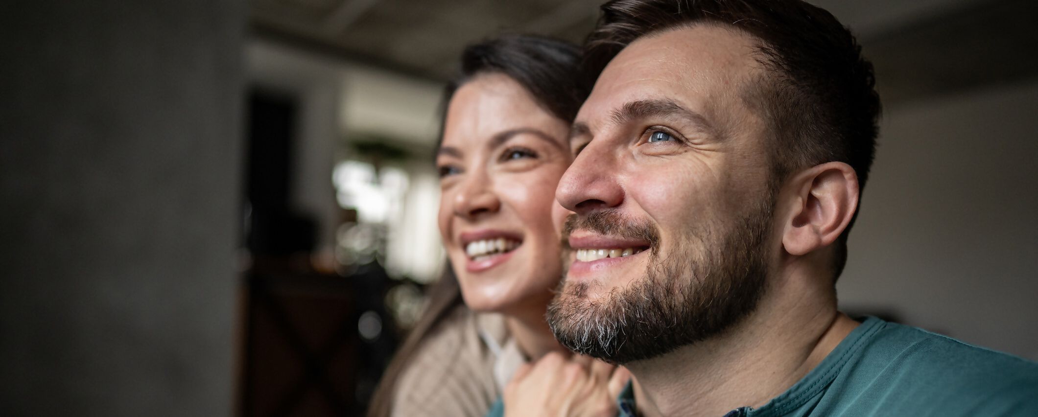 Zdjęcie przedstawia uśmiechniętą parę patrzącą z nadzieją w przyszłość.