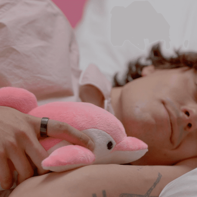 Osoba śpiąca ze smart pierścieniem na dłoni – monitorowanie snu